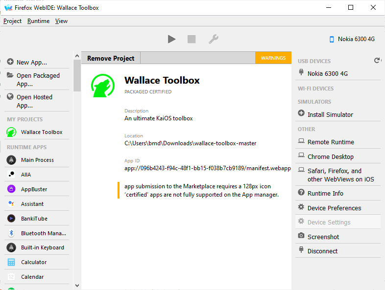 Firefox WebIDE showing the loaded 'Wallace Toolbox' KaiOS app project. The project panel displays the app’s name, description, local file path, and app ID. A warning notes that Marketplace submission requires a 128px icon and that 'certified' apps are not fully supported. On the top, the first button 'Install and Run' is lit up